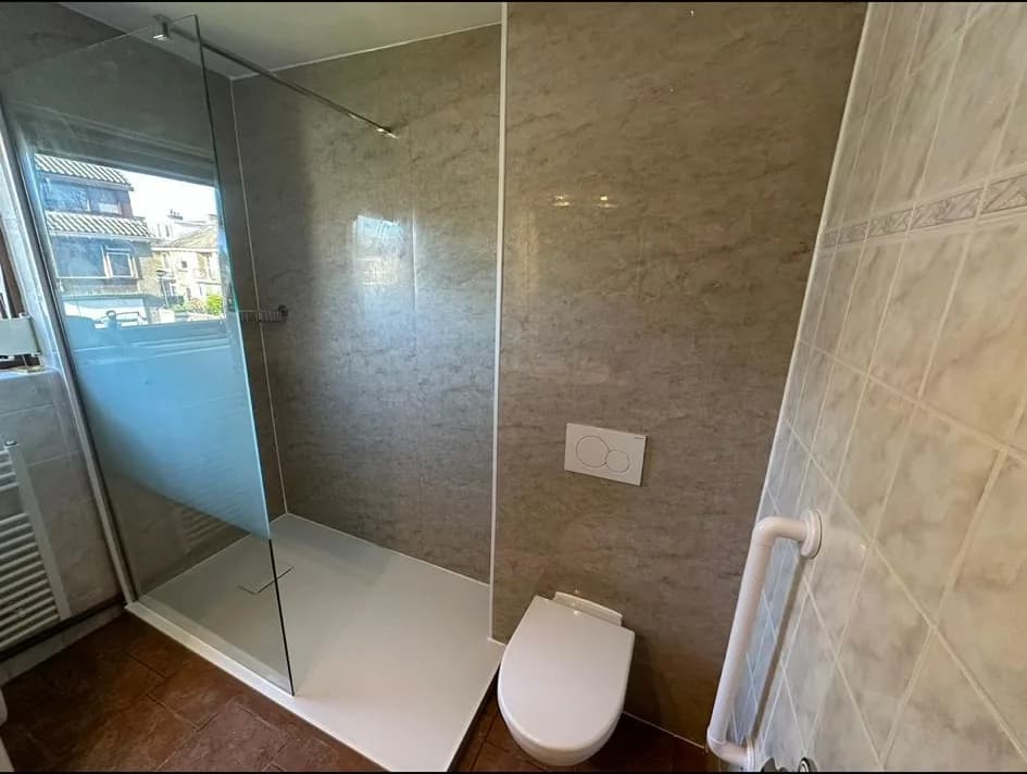 Badkamer met inloopdouche achter glazen wand en hangtoilet